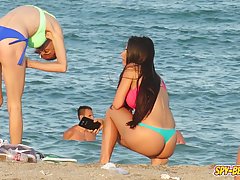 Adorable girls are having a great time on the beach while guys are checking out their asses