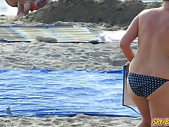 Topless ladies are enjoying on the beach even while guys are staring at their tits