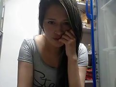 Dark haired babe is secretly masturbating in front of the camera, in the storage room